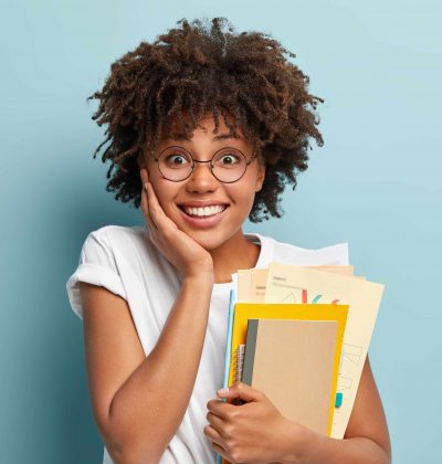 pleasant-looking-afro-american-woman-holds-notepads-papers-studies-college-glad-finish-studying-min